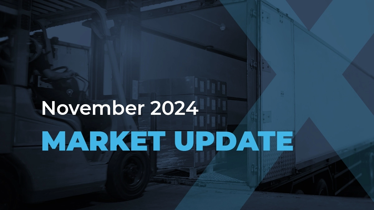 A forklift loads boxes into a truck. Text over the image reads: November 2024 MARKET UPDATE. The scene is blue-toned and industrial.